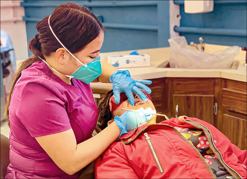 Cinthia Tovar treats one of her first patients at the new dental clinic in Valle de la Trinidad, Baja, Mexico, where she is now a practicing dentist. Giving back to the local community is value Cinthia holds dear as she grew up at the El Oasis Children's Village not far from Valle.
